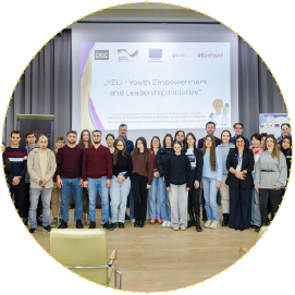 Group photo of young participants and organisers at a Youth Empowerment and Leadership Initiative (YELI) event, standing on stage in front of a presentation screen.