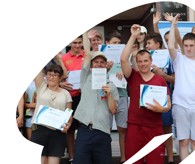 Young people and adults holding certificates during an EU4Youth-supported training or community programme, celebrating successful completion of activities.