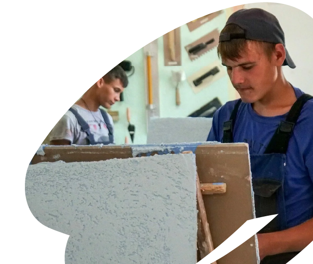 Young participants engaged in hands-on vocational training, developing technical and construction-related skills through practical work.