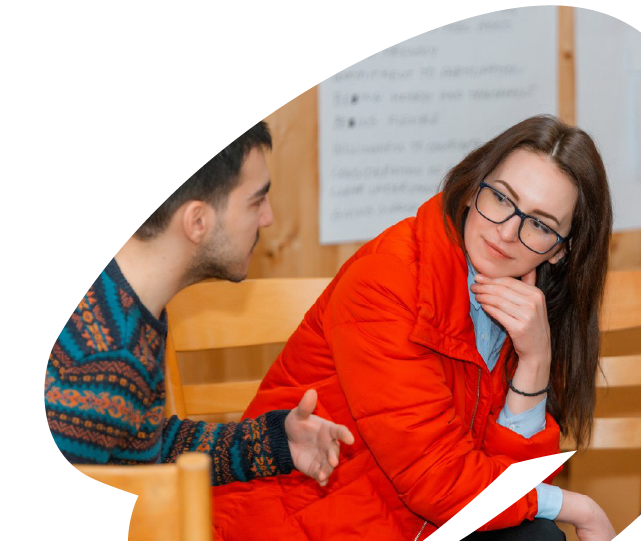 Two young participants engaged in discussion during an EU4Youth training or mentoring session, reflecting collaboration and peer learning.