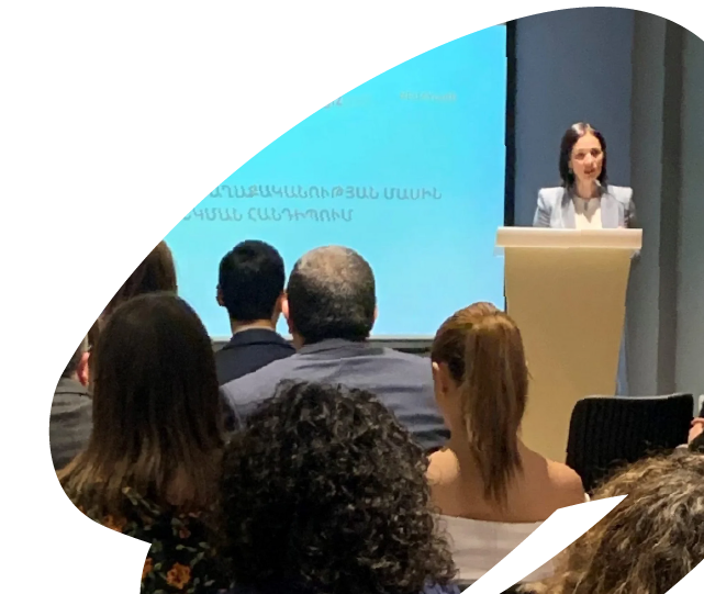 Speaker addressing an audience during an EU4Youth conference or policy event, presenting to participants in a formal setting.