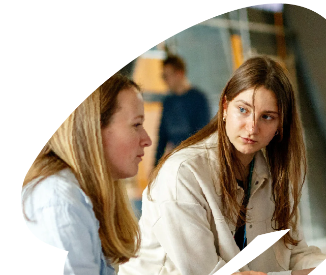Two young participants engaged in conversation during an EU4Youth training or mentoring activity, reflecting peer exchange and collaborative learning.