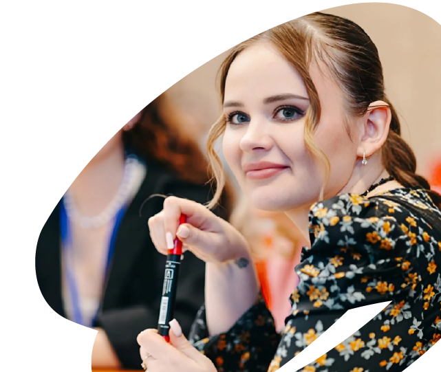 Young woman participating in an EU4Youth workshop or training session, holding a marker and engaging in a group activity.